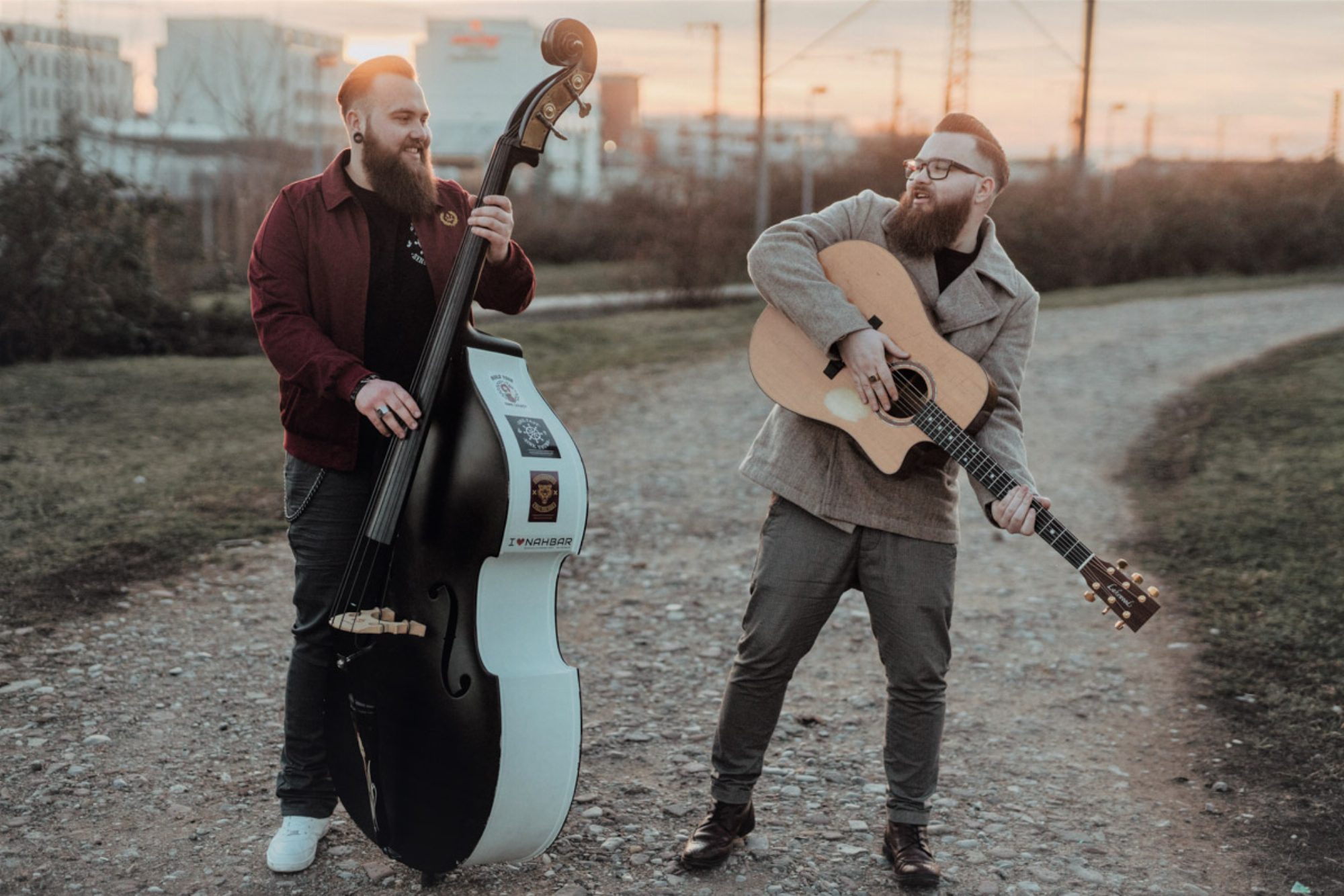 Jan und Tim Heuser mit Gitarre und Kontrabass im Abendlicht
